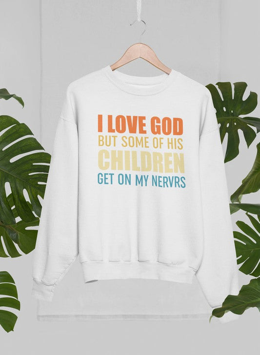 White sweatshirt with colorful text on a hanger against a light gray background with green leaves.