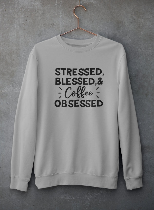 Gray sweatshirt with 'Stressed, Blessed & Coffee Obsessed' text on a gray background